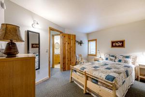 a bedroom with a bed and a desk with a lamp at Pebbles & Sunshine in Lakeside