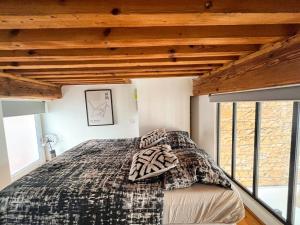 - une chambre avec un lit dans une pièce dotée de plafonds en bois dans l'établissement Suite Cartier, à Lyon