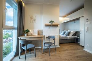um quarto com uma secretária, 2 cadeiras e uma cama em WiguryTower Apartaments 92 em Lódź