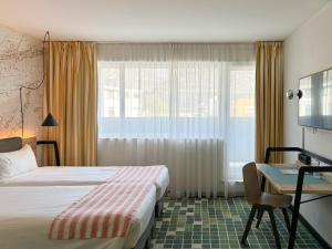 Rúm í herbergi á Nonanteneuf appart hōtel Sierre - contactless check-in
