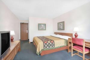 a hotel room with a bed and a flat screen tv at Super 8 by Wyndham Queensbury Glens Falls in Queensbury