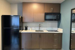 cocina con nevera negra y microondas en Baymont by Wyndham Coalinga, en Coalinga
