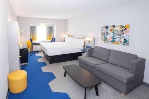 een hotelkamer met een bed en een bank bij Microtel Inn & Suites Springville in Springville