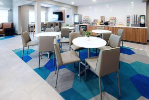 - une salle d'attente avec des tables et des chaises dans l'établissement Microtel Inn & Suites Springville, à Springville