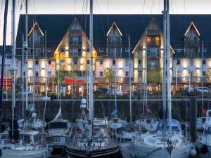 a group of boats docked in front of a building at ibis Deauville Centre in Deauville