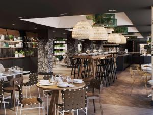 a restaurant with tables and chairs and a bar at Novotel Bordeaux Centre Ville in Bordeaux