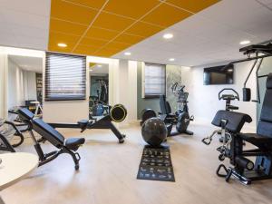 a gym with several exercise equipment in a room at Novotel Bordeaux Centre Ville in Bordeaux