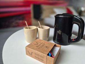 una taza de café negra y una caja en una mesa en Novotel Bordeaux Centre Ville, en Burdeos