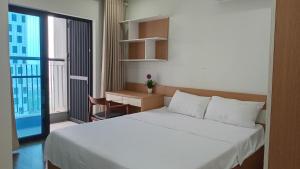 - une chambre avec un grand lit blanc et un bureau dans l'établissement Goldmark city 3PN sang trọng, à Hanoï