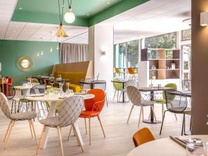 - un restaurant avec des tables et des chaises dans une salle dans l'établissement Ibis Cavaillon Portes du Luberon, à Cavaillon