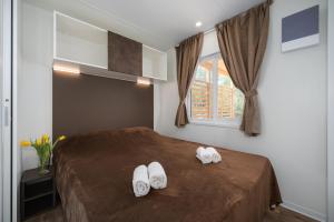 sypialnia z łóżkiem z białymi butami w obiekcie Mobile Homes Adriamar - FKK Nudist Camping Solaris w Poreču
