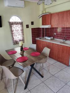 a kitchen with a wooden table with red plates on it at Villa Elli in Olympic Beach