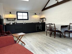 een keuken en een woonkamer met een tafel en stoelen bij The Dairy in Sutton