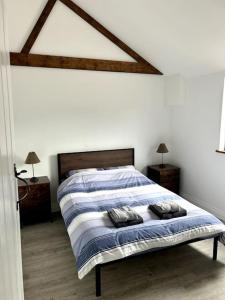 een slaapkamer met een bed met 2 kussens erop bij The Dairy in Sutton