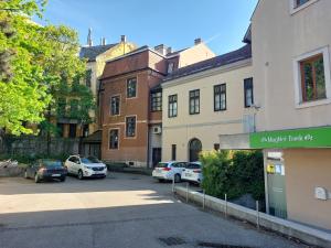 un aparcamiento con coches estacionados frente a los edificios en Color Home en Veszprém