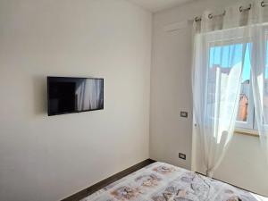 a bedroom with a flat screen tv on the wall at Tower Apartments in Terracina