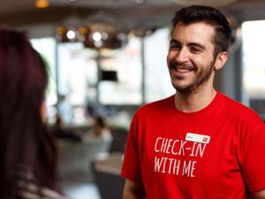 a man in a red shirt talking to a woman at ibis London City - Shoreditch in London