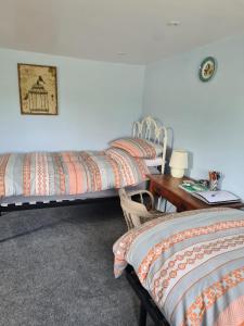 a room with two beds and a desk with a table at Morland in Burrowbridge