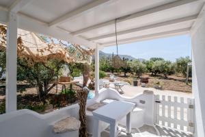 a white porch with a white table and chairs at Bonzoe #5 in Parikia