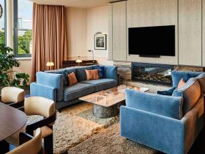 a living room with blue furniture and a fireplace at Sofitel Brussels Europe in Brussels