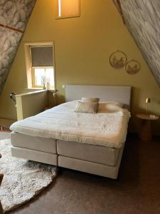 a bedroom with a white bed in a attic at Bed bij Bistro in Medemblik