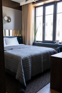 a bedroom with a bed and large windows at Four Sisters Luxury Rooms in Siauliai in Šiauliai