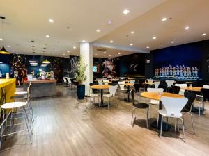 um restaurante com mesas e cadeiras e um bar em ibis Joinville em Joinville