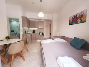 a living room with a large bed and a kitchen at Eva Ivoni apartments in Amoudara Herakliou