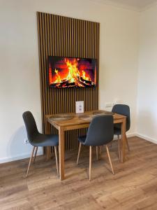 a room with a table and chairs with a fireplace at Residenz am Kurpark - Ferienwohnungen in zentraler Lage I Privatparkplatz in Bad Rothenfelde