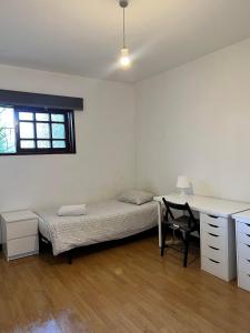 a bedroom with a bed and a desk and a desk at Asprela Guest House in Porto
