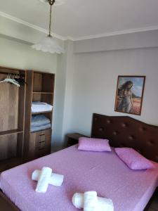 um quarto com uma cama roxa com toalhas em Villa Elli em Olympiakí Aktí