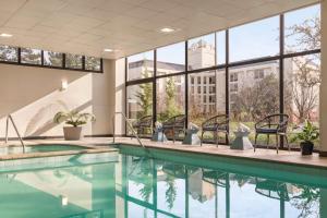 a swimming pool in a building with windows at Embassy Suites by Hilton Kansas City Overland Park in Overland Park