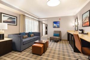 a hotel room with a couch and a chair at Embassy Suites by Hilton Kansas City Overland Park in Overland Park