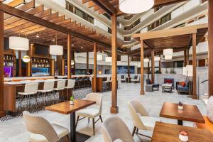 a restaurant with tables and chairs and a bar at Embassy Suites by Hilton Kansas City Overland Park in Overland Park