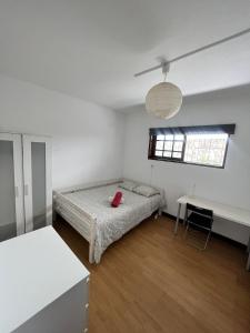 um quarto branco com uma cama e uma secretária em Asprela Guest House em Porto