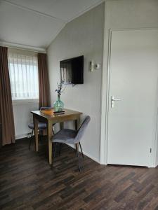 Habitación con mesa, silla y puerta en Veerhuys Tante Jet, en Blitterswijck