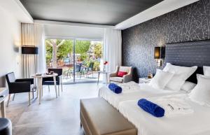 a hotel room with two beds and a table and chairs at Barceló Corralejo Bay - Adults Only in Corralejo