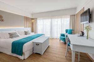 a hotel room with a bed and a desk at Barceló Corralejo Bay - Adults Only in Corralejo