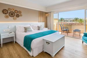 a bedroom with a large bed and a balcony at Barceló Corralejo Bay - Adults Only in Corralejo