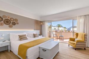 a hotel room with a bed and a balcony at Barceló Corralejo Bay - Adults Only in Corralejo