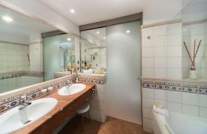 a bathroom with two sinks and a large mirror at Barceló Corralejo Bay - Adults Only in Corralejo