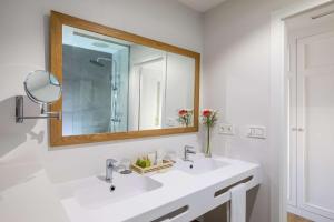 a white bathroom with a sink and a mirror at Barceló Corralejo Bay - Adults Only in Corralejo