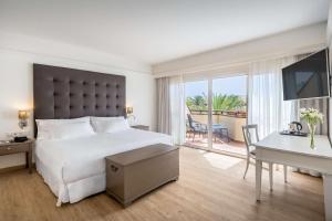 a hotel room with a bed and a desk and a computer at Barceló Corralejo Bay - Adults Only in Corralejo