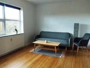 Sala de estar con sofá azul y mesa de centro en id201 Vinkelvej 19 1sal th, en Varde