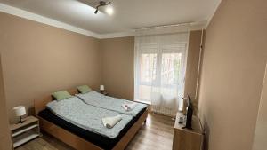 a small bedroom with a bed and a window at Kiss Vendégház 1. in Kaposvár