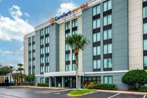 a hotel with a palm tree in front of a building at Comfort Suites Baymeadows Near Butler Blvd in Jacksonville
