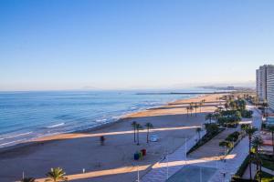 a view of a beach with palm trees and the ocean at El Séptimo Cielo de la Bahía de los Naranjos - Primera Línea de Playa in Cullera