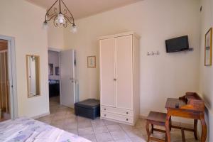 ein Schlafzimmer mit einem Bett, einem Schrank und einem Schreibtisch in der Unterkunft Casa Vacanze Il Gatto Rosso in Trecase