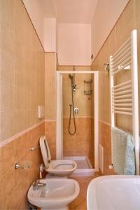 ein Badezimmer mit 2 WCs und einer Dusche in der Unterkunft Casa Vacanze Il Gatto Rosso in Trecase