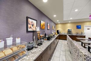 a cafeteria with a counter with aasteryasteryasteryasteryasteryasteryasteryasteryastery at Comfort Inn & Suites Lovington in Lovington